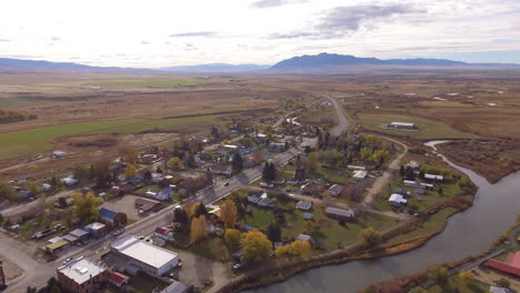 Small-Montana-town-along-river-in-beautiful-sunset-light-of-fall,-drone-shot,-Twin-Bridges