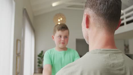 Niño-Caucásico-Abrazando-A-Su-Padre-En-La-Sala-De-Estar-De-Casa