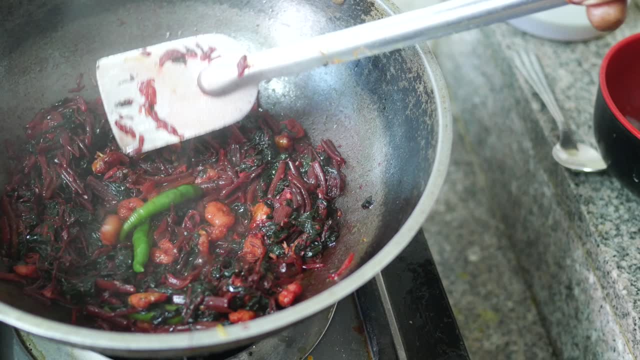 Cooking red spinach in a cooking pan top view