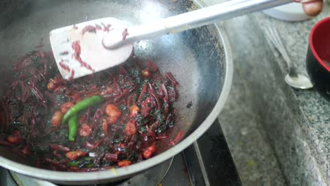 cooking red spinach in a cooking pan top view