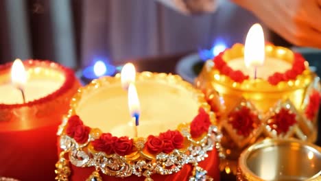 primer plano de velas encendidas con decoraciones rojas y doradas