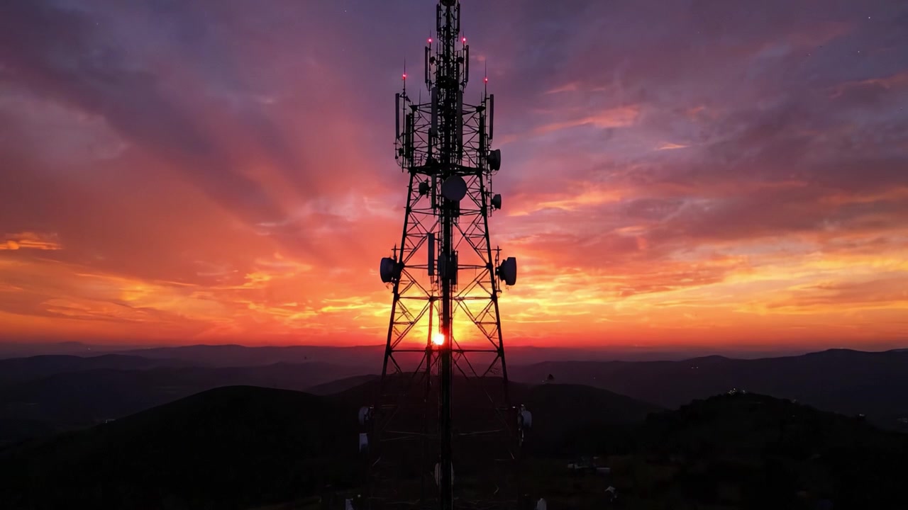 Imposing telecommunications tower silhouette against a breathtaking sunset sky, illustrating the intersection of technology and nature in a stunning visual display.