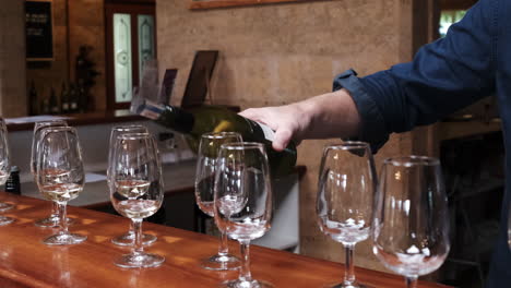 bartender pours white wine over the glasses for a tasting tour