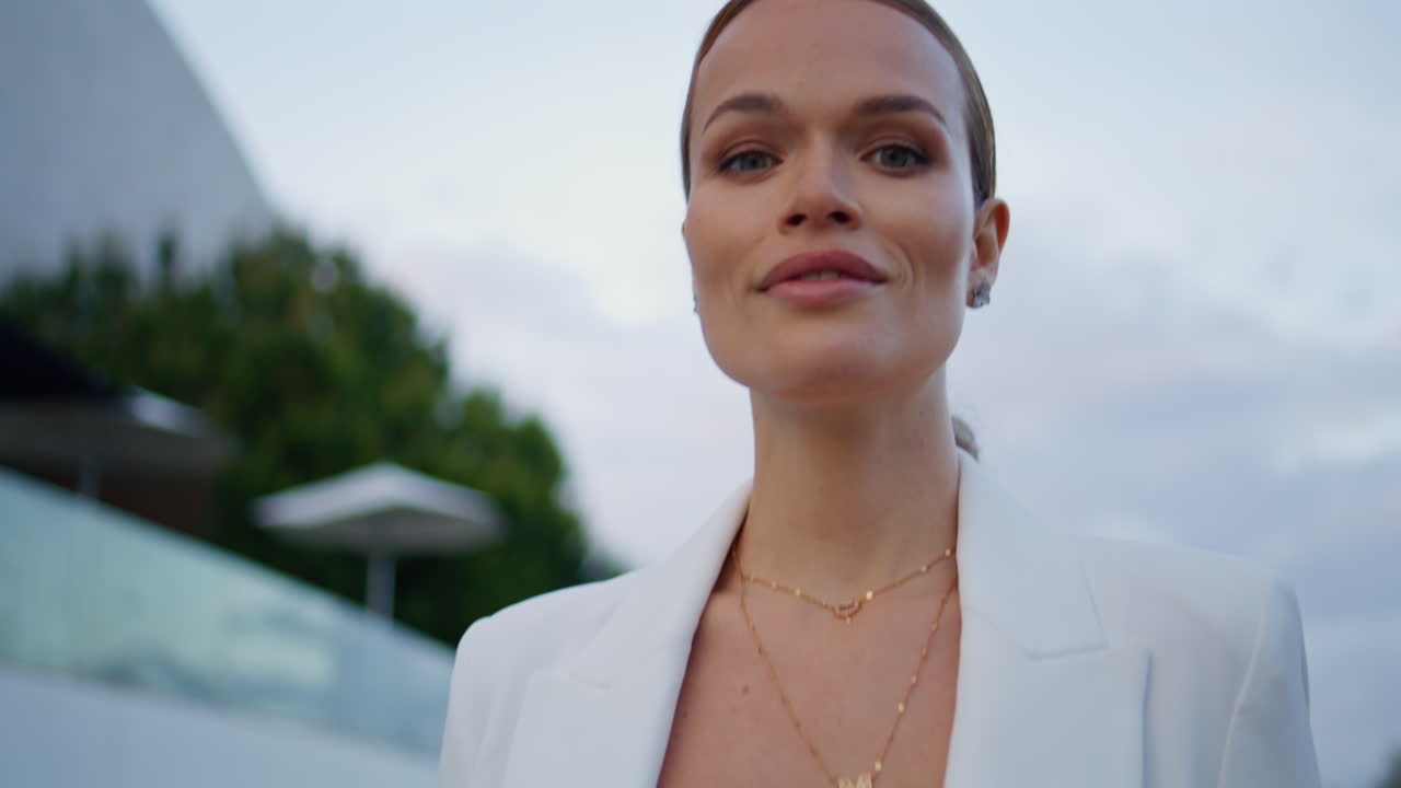 멋진 모델이 거리를 걸어다니며 카메라를 쳐다보며 자신감 있게 클로즈업. 걸어가는 여인