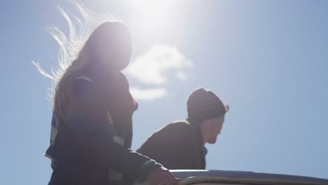 A-couple-stands-in-the-bed-of-a-pickup-truck-as-it-drives-along-a-rural-road-1