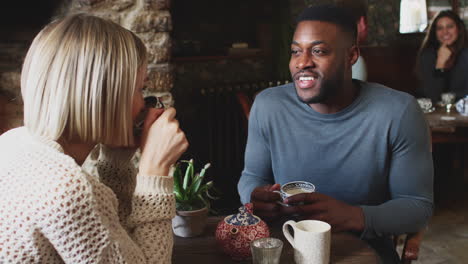 close up of couple sitting at table drinking tea in traditional english holiday hotel