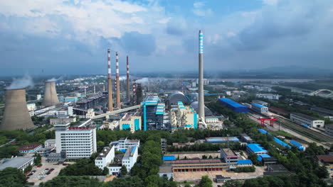 aerial view of a large industrial power plant with chimneys and cooling towers