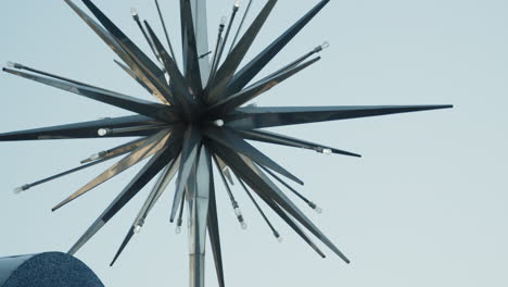 a close-up shot features the iconic star symbol of reno spinning atop a sign, with sunlight reflecting off its surface during the day, creating a shimmering effect that highlights its design.