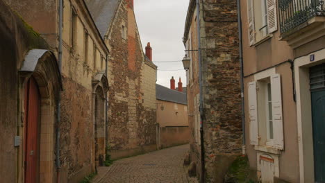 empty narrow cobbled street alley in the medieval town of angers, france at daytime