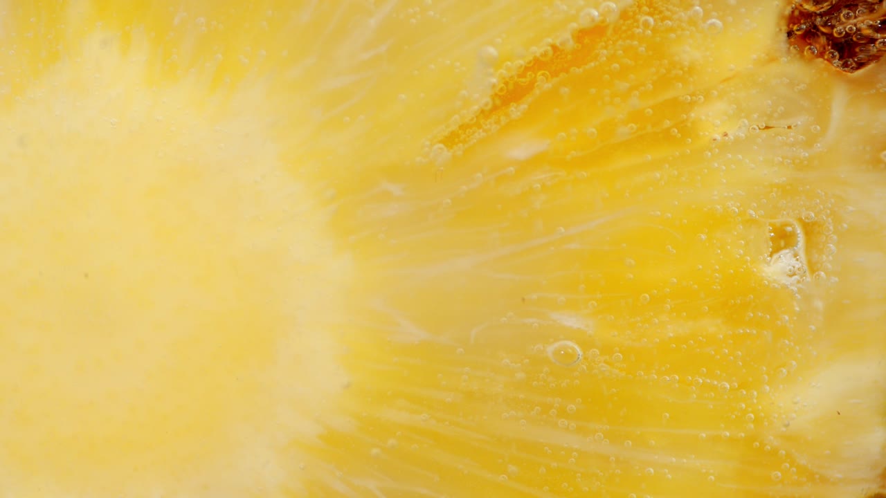 공기 거품이 있는 물 에 익은 파인애플 한 조각.