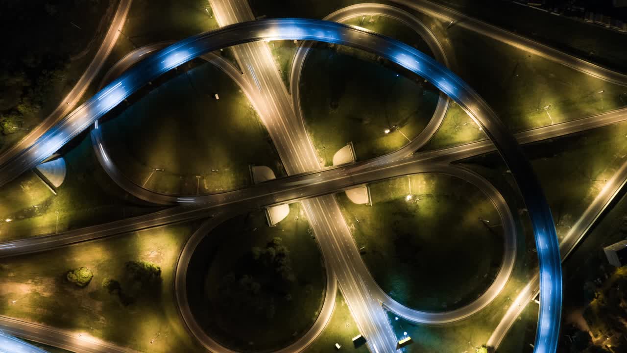 Hyperlapse timelapse of night city traffic on stop street intersection circle roundabout in megalopolis. 4K UHD aerial view.