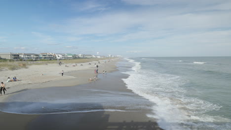 People at the beach enjoying the sunshine waves breaking along shore