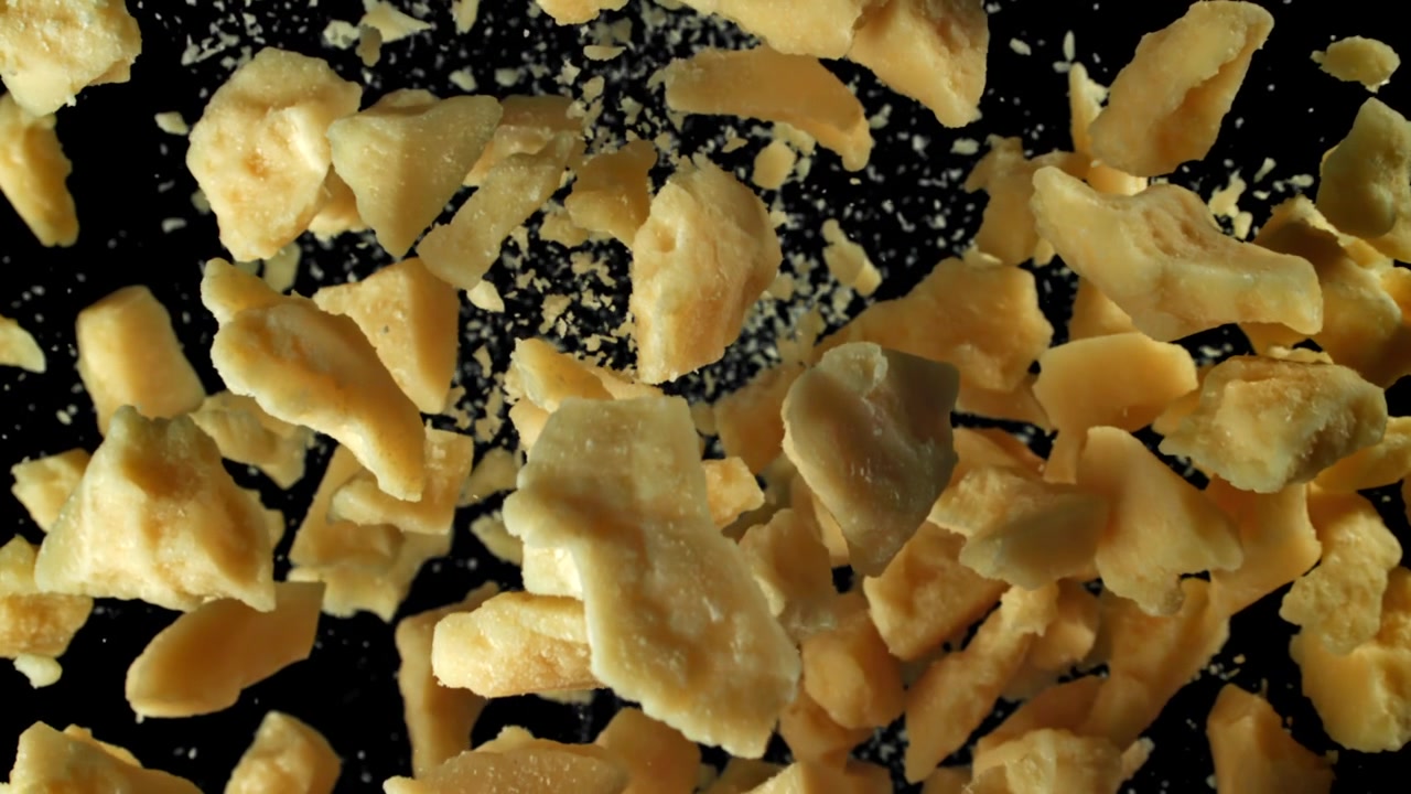 Delicious Parmesan Cheese Pieces Falling in Slow Motion