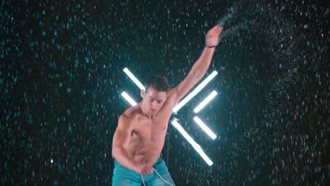 martial arts tricking master performing amazing spinning flip kick in rain, slow motion