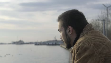 man looking sea from pier