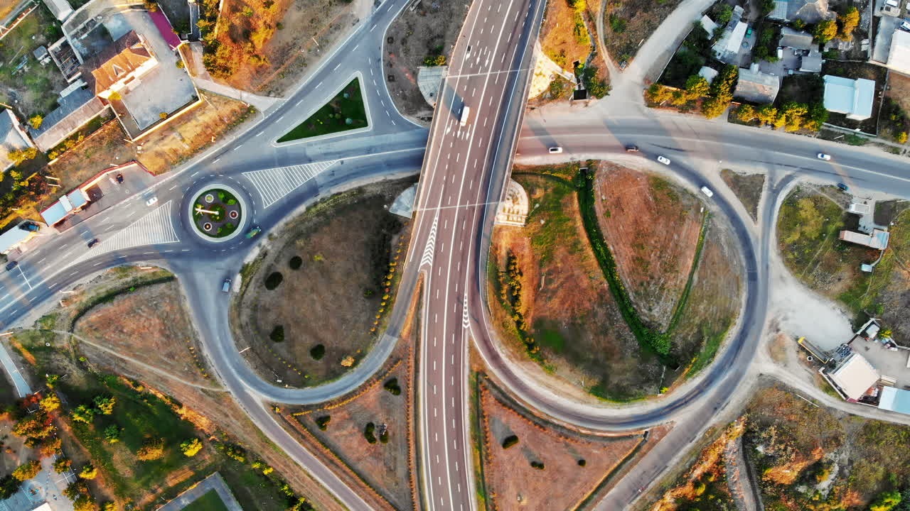 Multilevel ring roadway with moving cars in a village from north part of Moldova. Aerial drone view at sunset