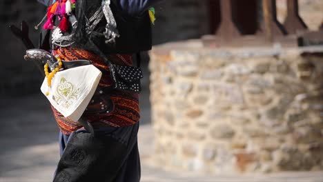 man playing zeybek in the street with his local clothes