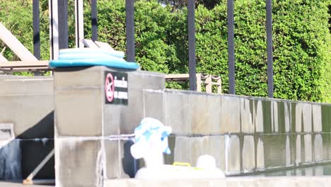 rubber ring thrown, lands over fence by pool.