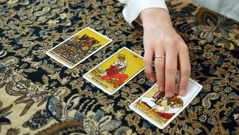 A-woman-giving-a-tarot-reading-with-the-king-of-pentacles-strength-and-the-knight-of-cups-cards