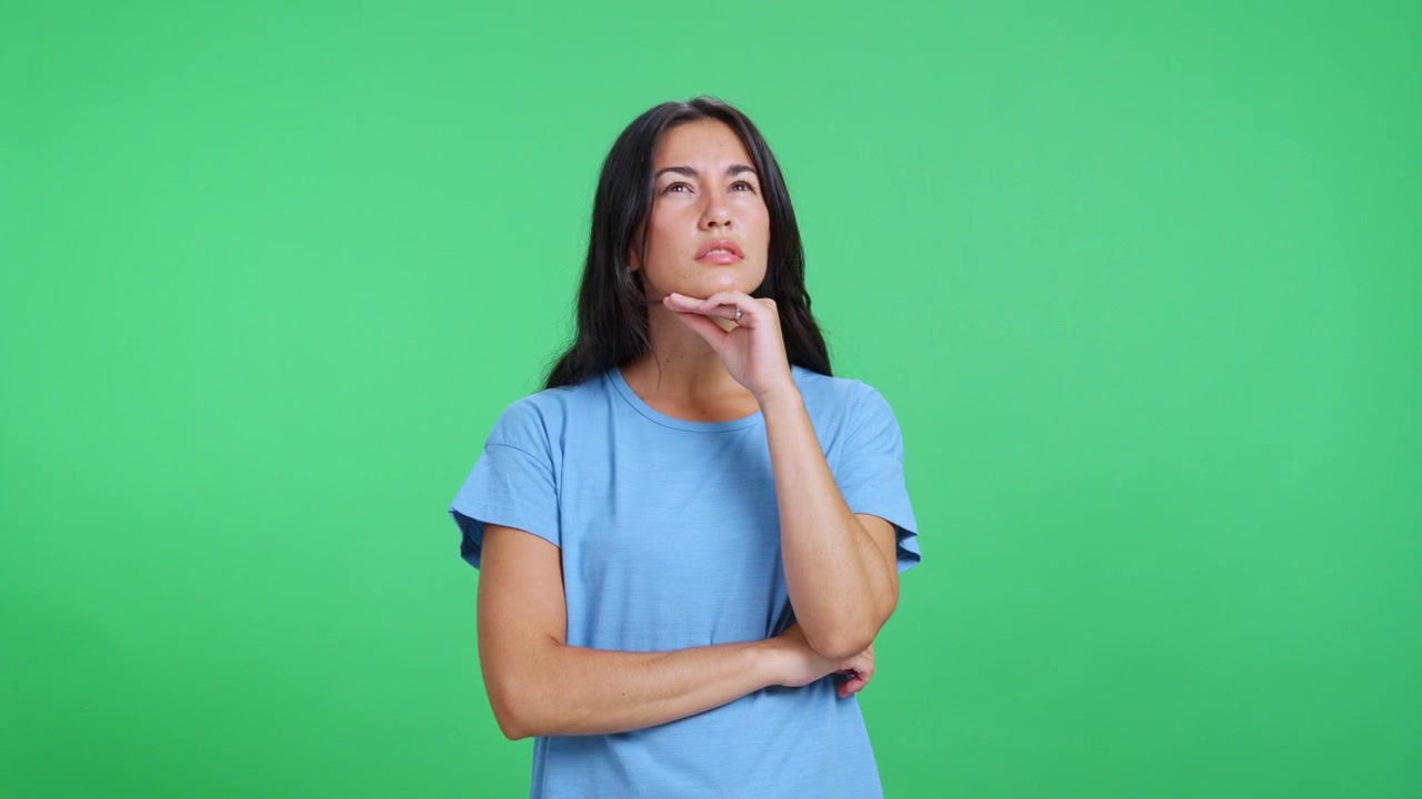 Young Woman Thinking and Looking Pensive Against a Green Screen