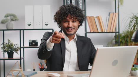 business man working on office laptop pointing to camera looking with happy expression making choice
