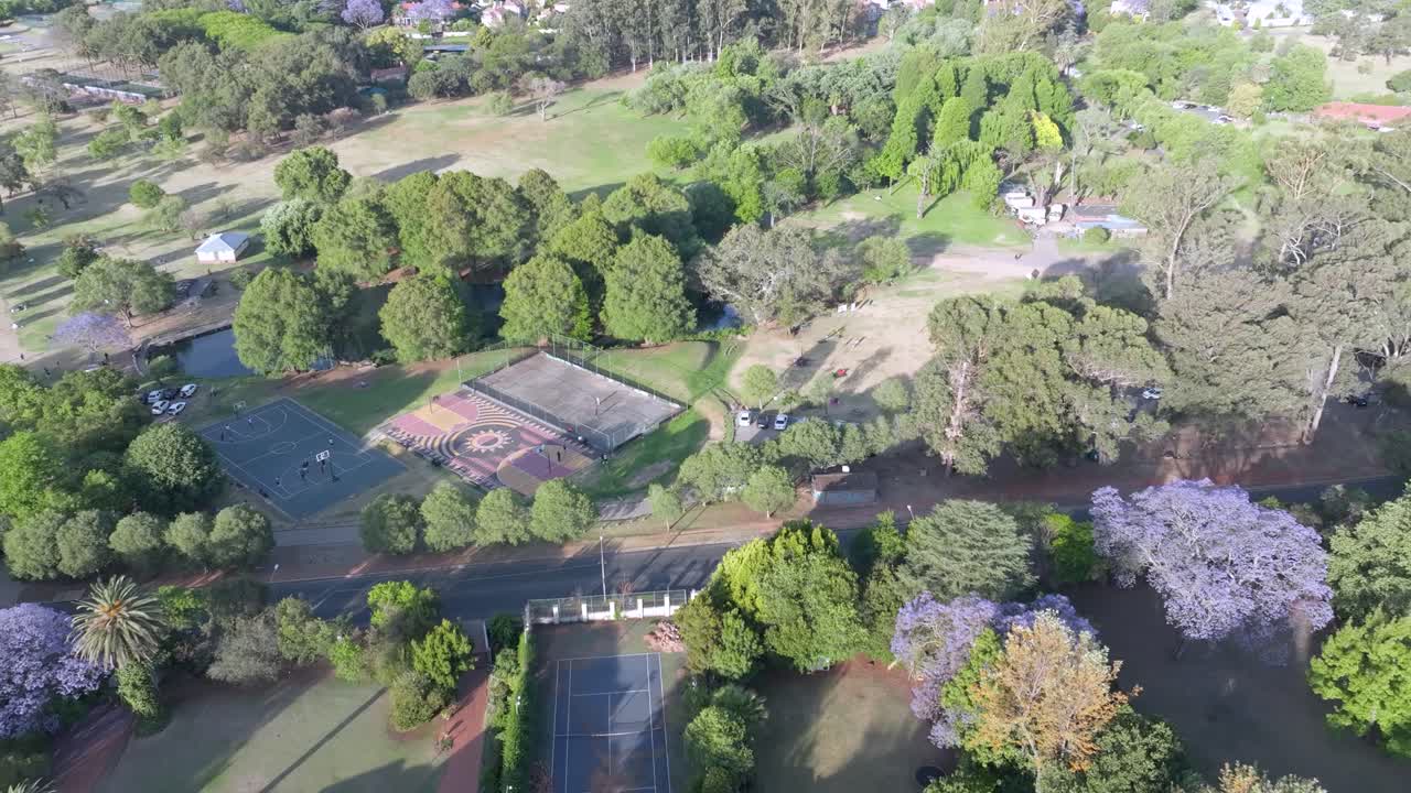 Lush green park in Northern Sandton, Johannesburg, South Africa with sports courts and scenic trees