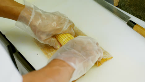 chef masculino preparando un rollo de arroz en la cocina 4k