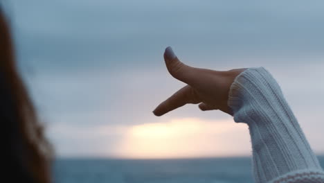 close up hand woman on beach feeling seaside breeze between fingers enjoying beautiful cloudy seaside