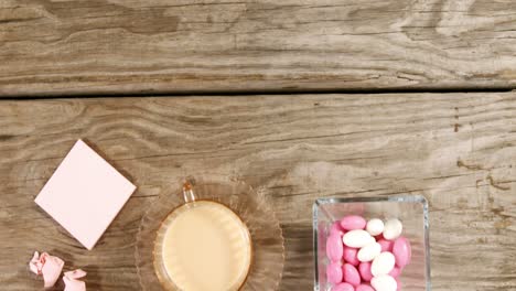 Candies,-cup-of-tea,-crumpled-paper-and-white-flowers