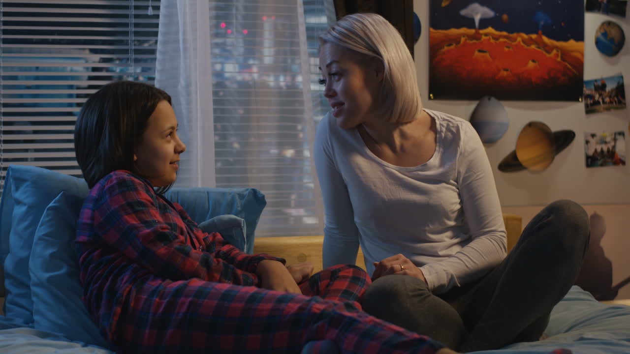 Mother and Daughter Talking in Bed at Night
