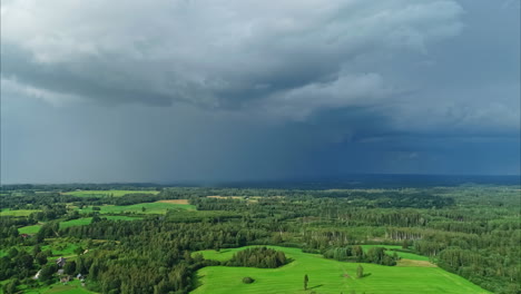 High-panoramic-aerial-view-of-a-green-landscape-under-ominous-storm-clouds