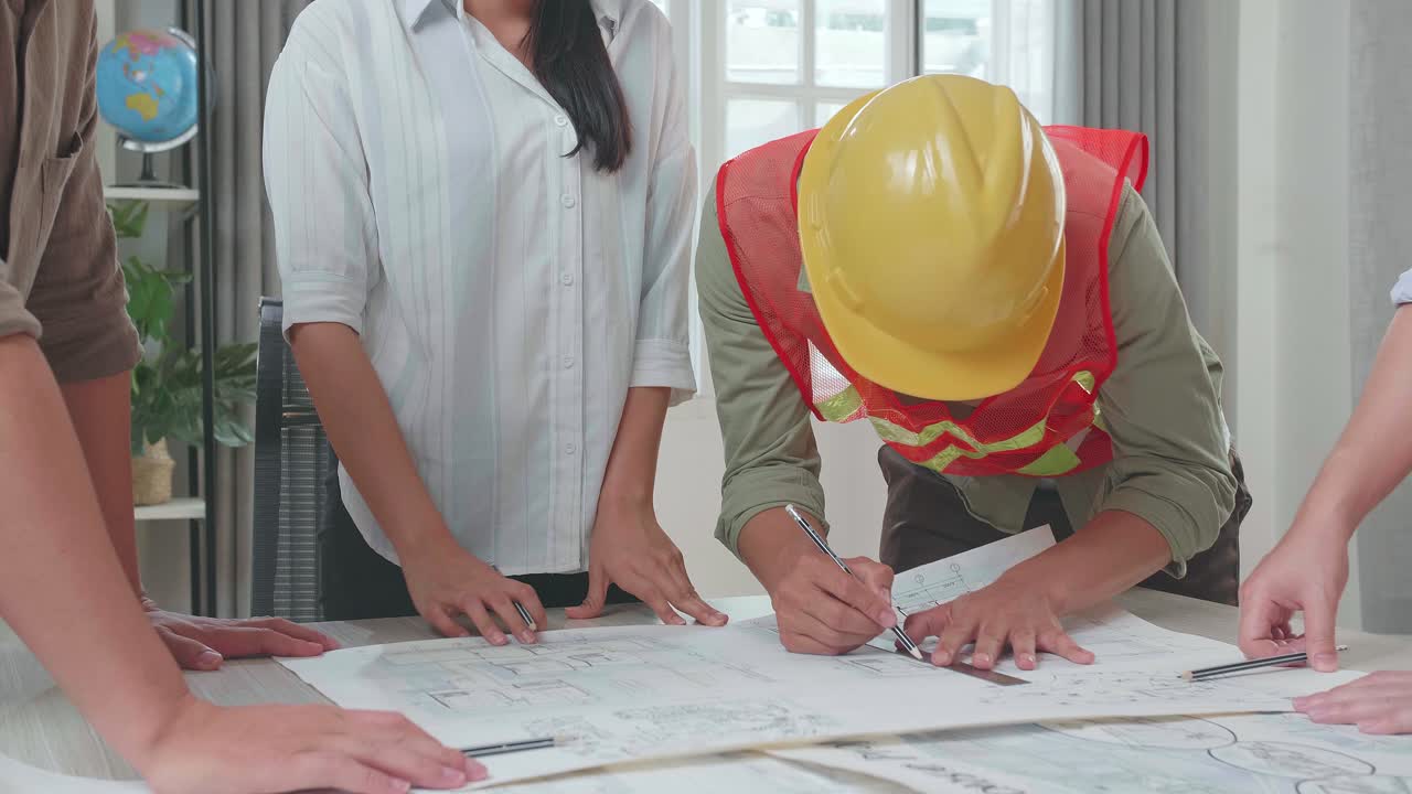 Three Asian Engineers With Helmets And A Man Celebrating Finish Drawing Building Construction While Working At The Office