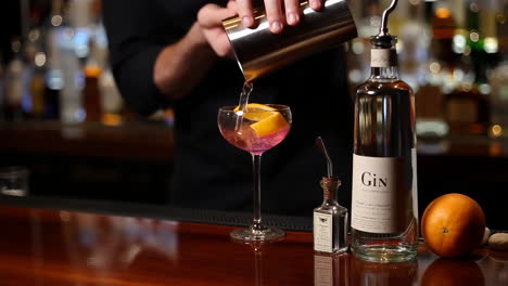 bartender pouring a cocktail at a bar