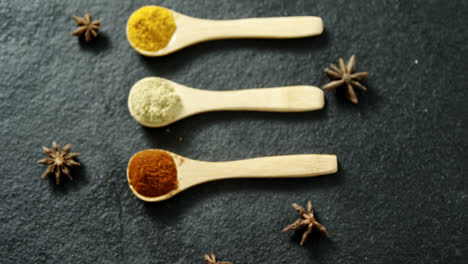 star anise with various spices powder in wooden spoon 4k