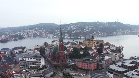 Vista-Sobre-La-Ciudad-De-Arendal-Con-Casas,-Edificios-E-Iglesia-Parroquial-En-Noruega---Disparo-Aéreo-De-Drones