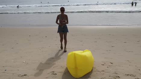 woman on the beach with inflatable chair