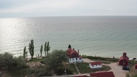 historic point betsie lighthouse in frankfort, michigan located along lake michigan with drone video from behind moving forward