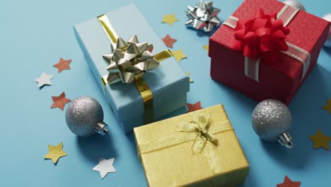 Video-of-christmas-decorations-with-presents-and-baubles-on-blue-background