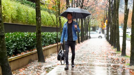 man holding an umbrella and walking on street