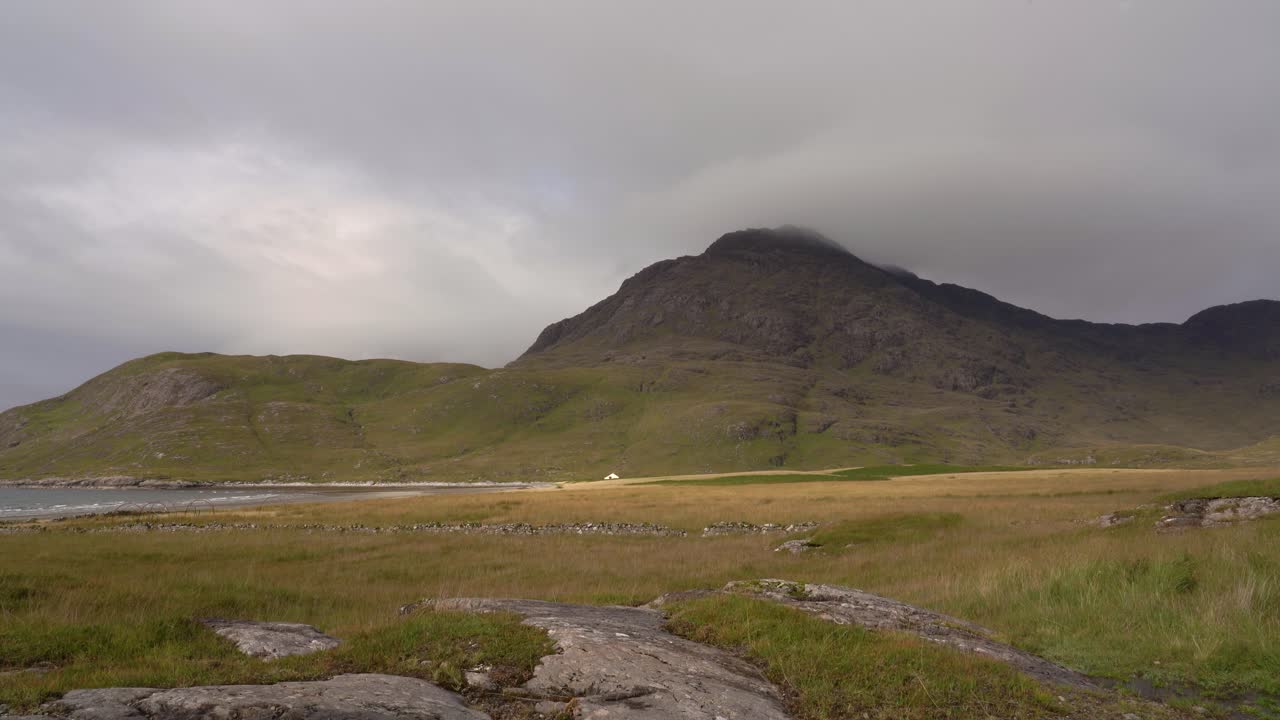 스코틀랜드 스카이 섬의 고립된 만에 산으로 둘러싸인 외딴 집