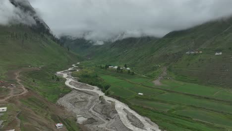 siga la toma del avión no tripulado sobre el lago y el valle verde en naran batakundi en la región norte de pakistán con nubes bajas