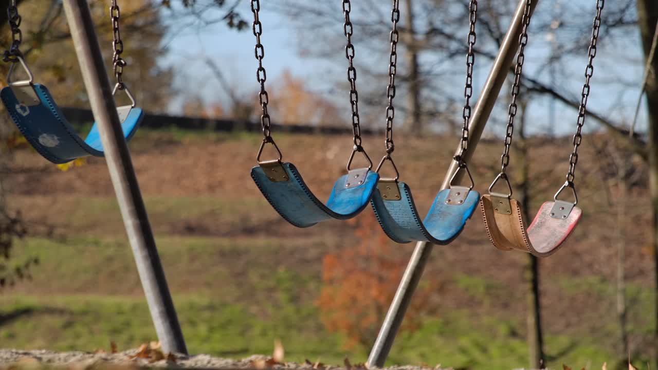 columpios vacíos en un patio de recreo en un día soleado, de cerca, en cámara lenta