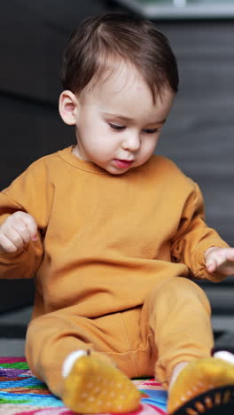 beautiful child having fun in the kitchen. adorable happy toddler holds the ladles playing and waving them. vertical video