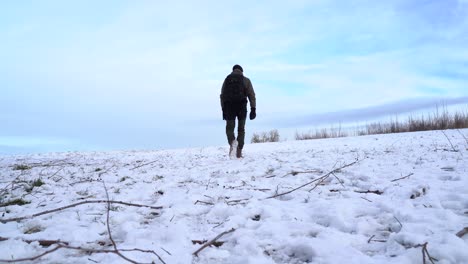 a man walks across a field with a lot of snow