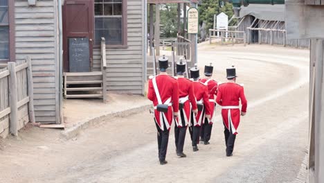 soldados con uniformes rojos marchando, turistas observando