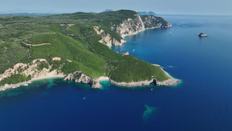 Costa-De-La-Isla-De-Corfú,-Aguas-Cristalinas-Del-Mar-Jónico,-Exuberante-Vegetación,-Día-Soleado,-Vista-Aérea