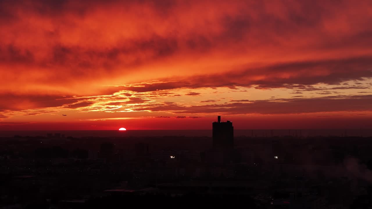 Flugzeuglandung und Stadtbild bei Sonnenuntergang.