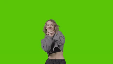 studio shot of young woman having fun dancing against green screen 22