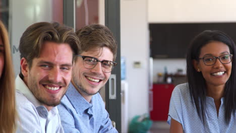 young adult work colleagues smiling to camera, close up pan