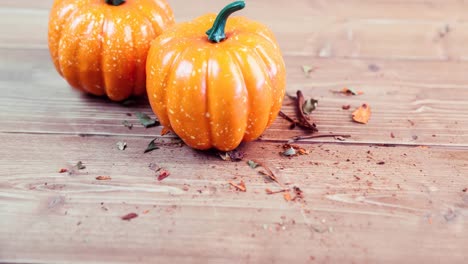 Animation-of-two-pumpkins-on-wooden-background